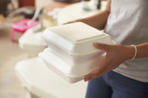 Person holding two polystyrene food containers